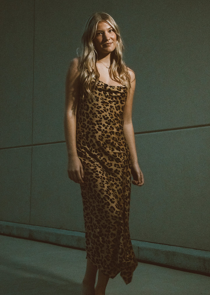 Woman wearing a leopard print dress against a neutral background