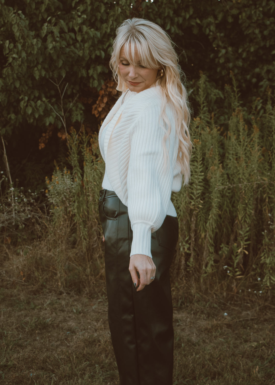 white shrug sweater and leather pants.