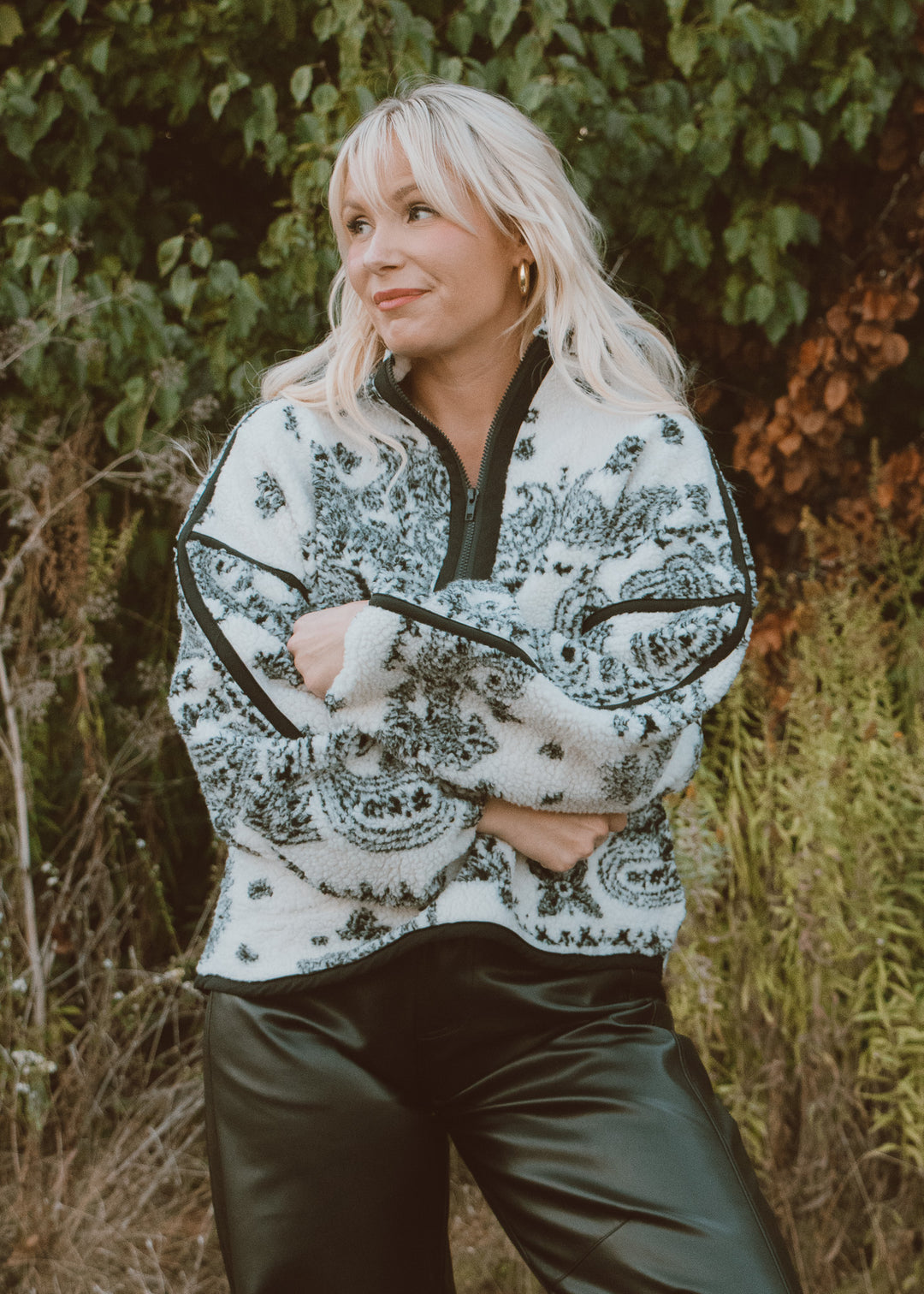Woman wearing a patterned jacket in a natural setting
