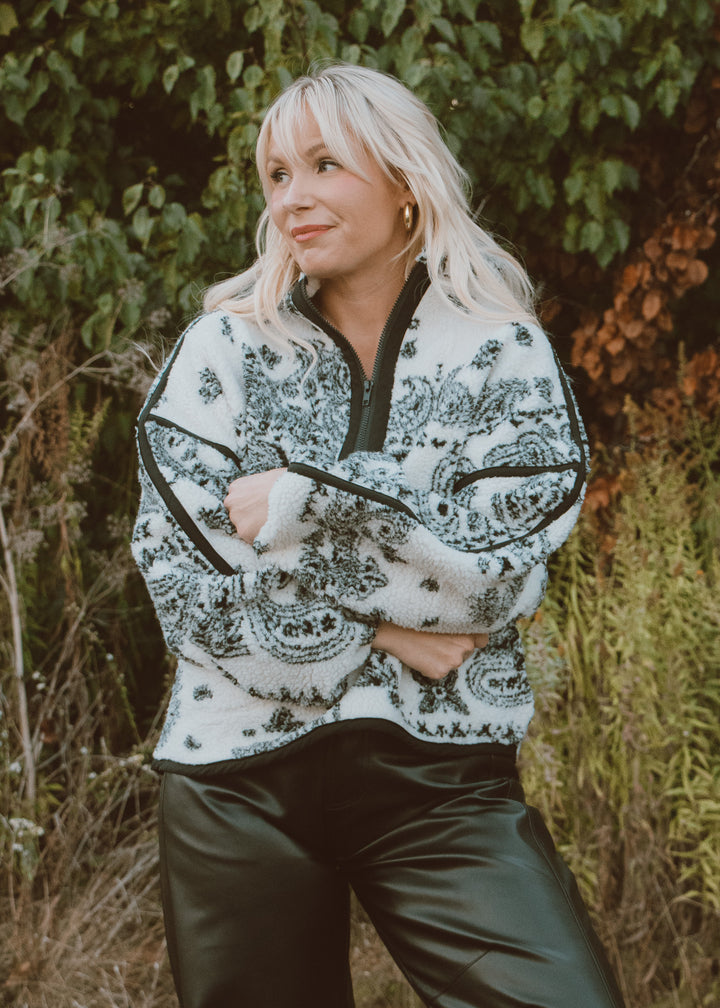 Woman wearing a patterned jacket in a natural setting