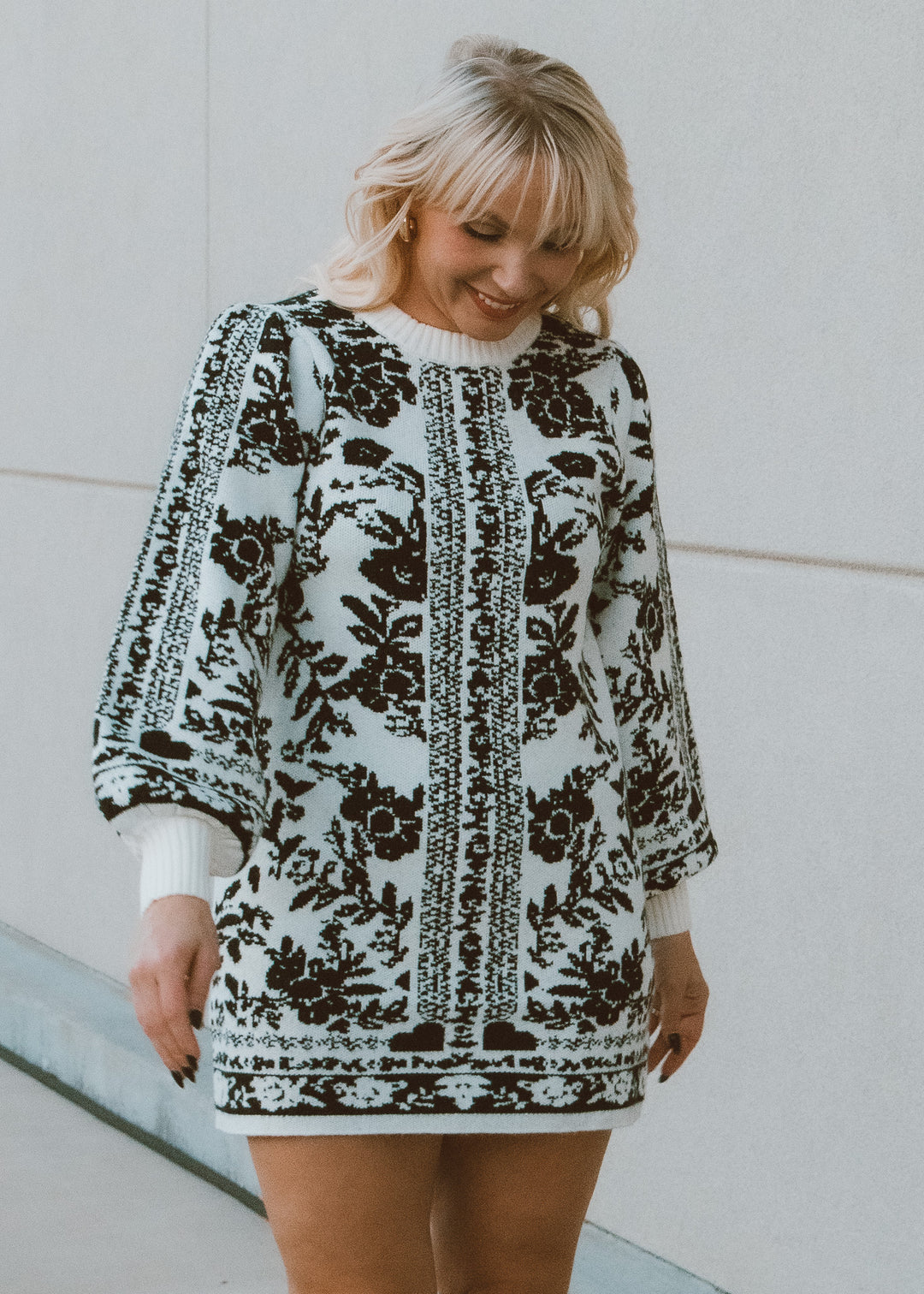 Woman wearing a patterned black and white dress against a white background