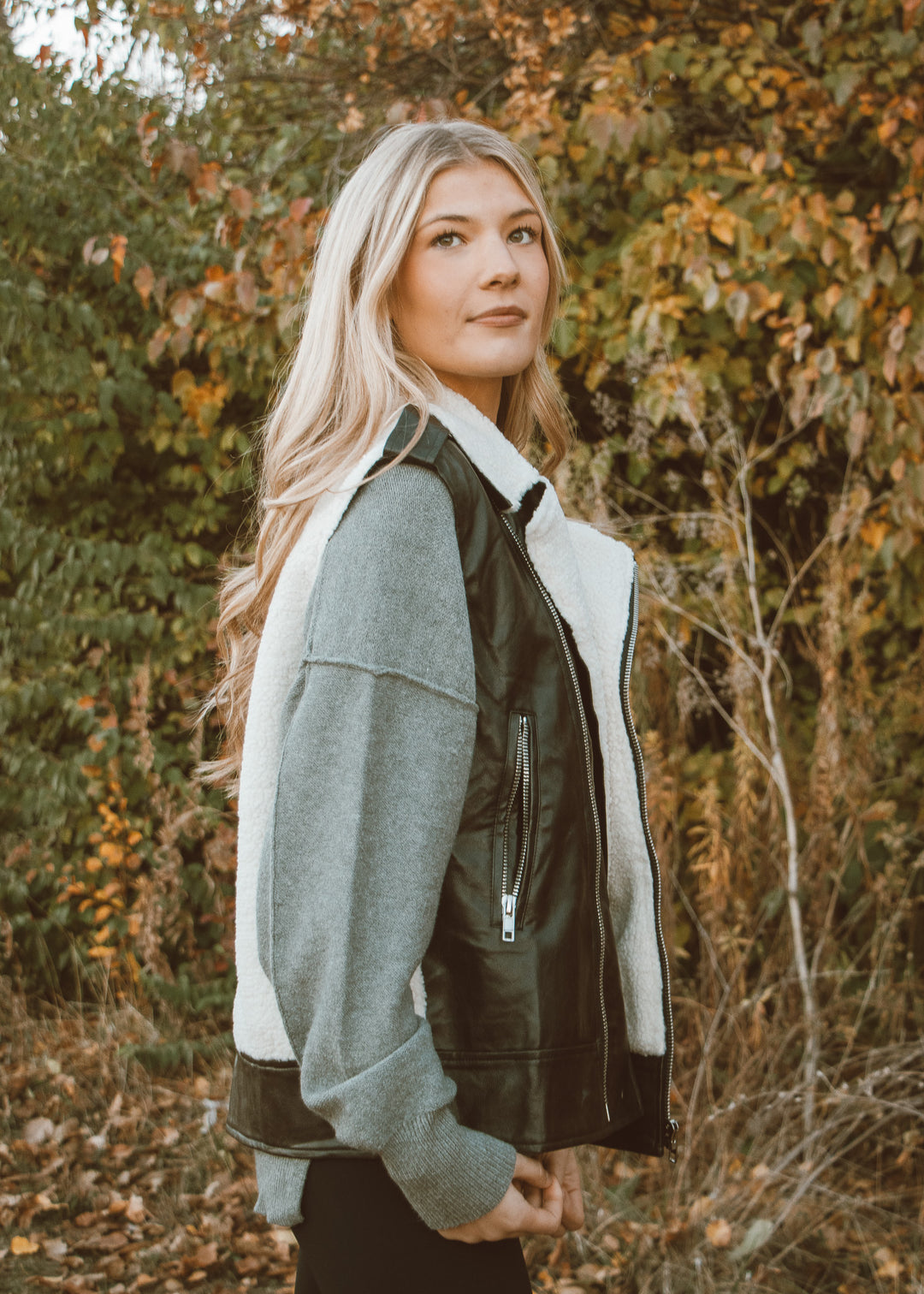 Woman wearing a green and white jacket in an autumn forest setting