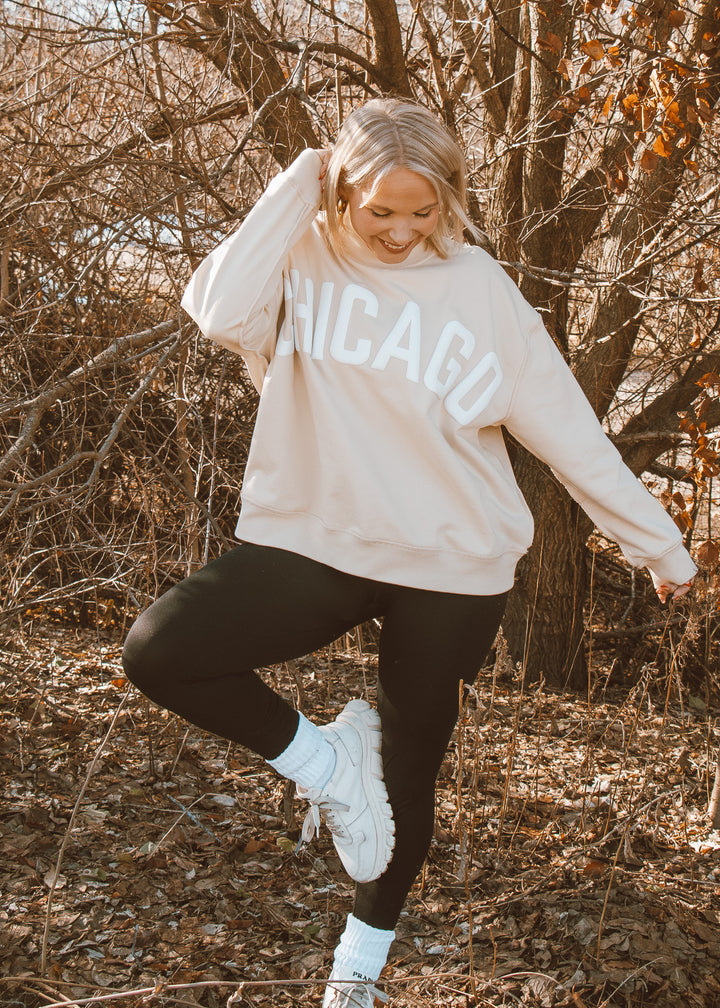 Person wearing a 'Chicago' sweatshirt in a forest setting