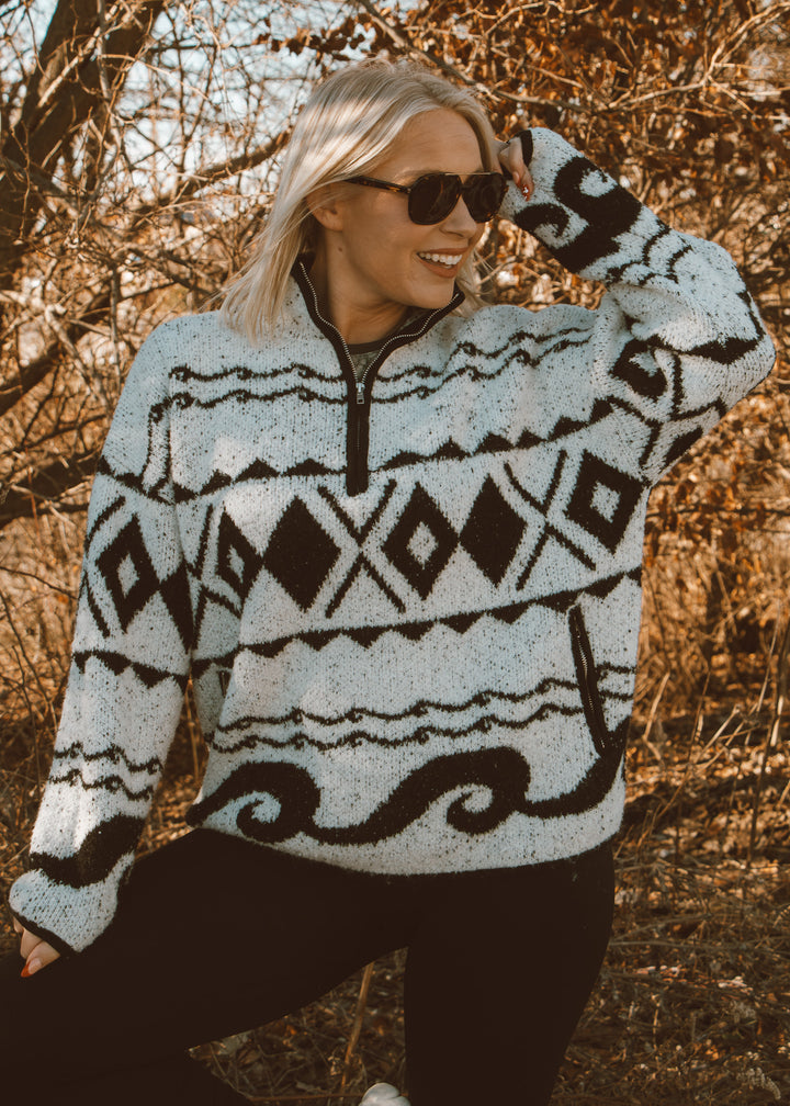Woman wearing a patterned sweater in a natural setting