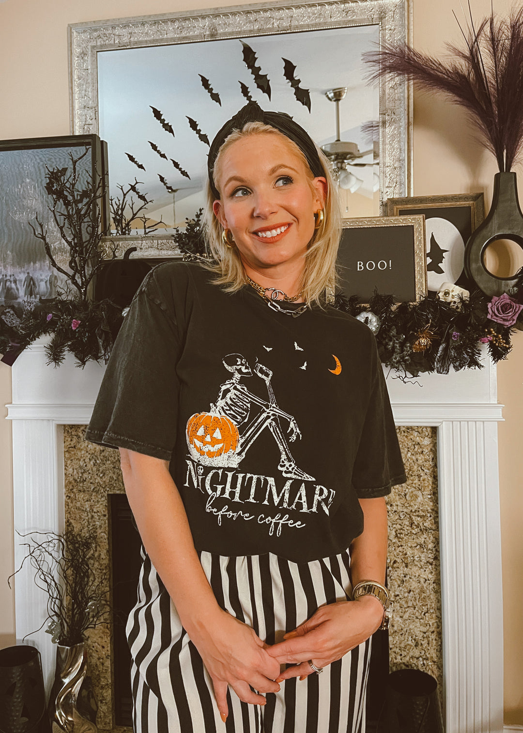 Person wearing a Halloween-themed t-shirt with decorative elements in the background