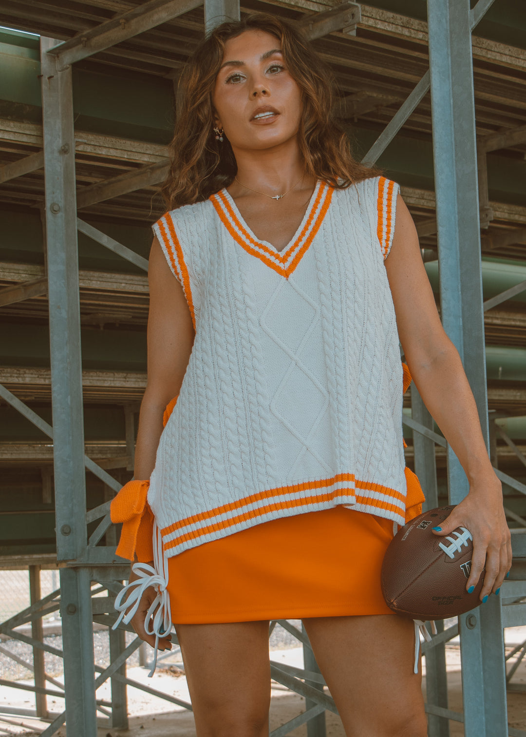 White and orange sweater vest with bow detailing 