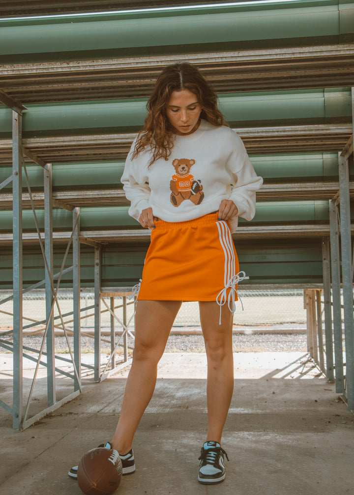 Orange athletic skirt with white detailing 