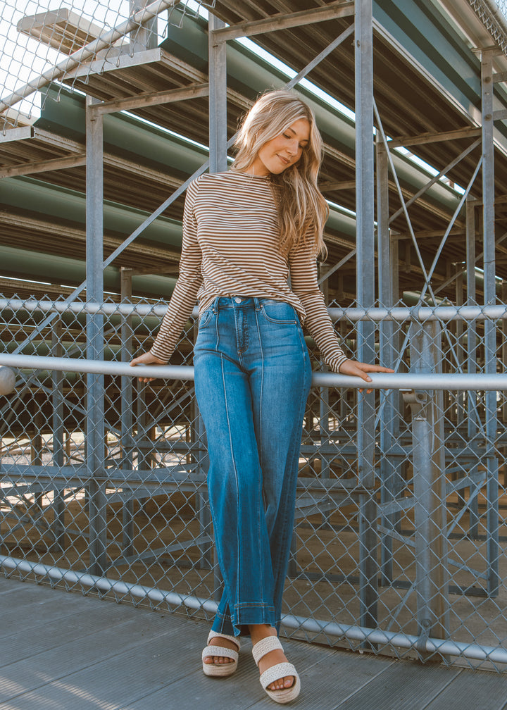 Woman in striped shirt and blue jeans.