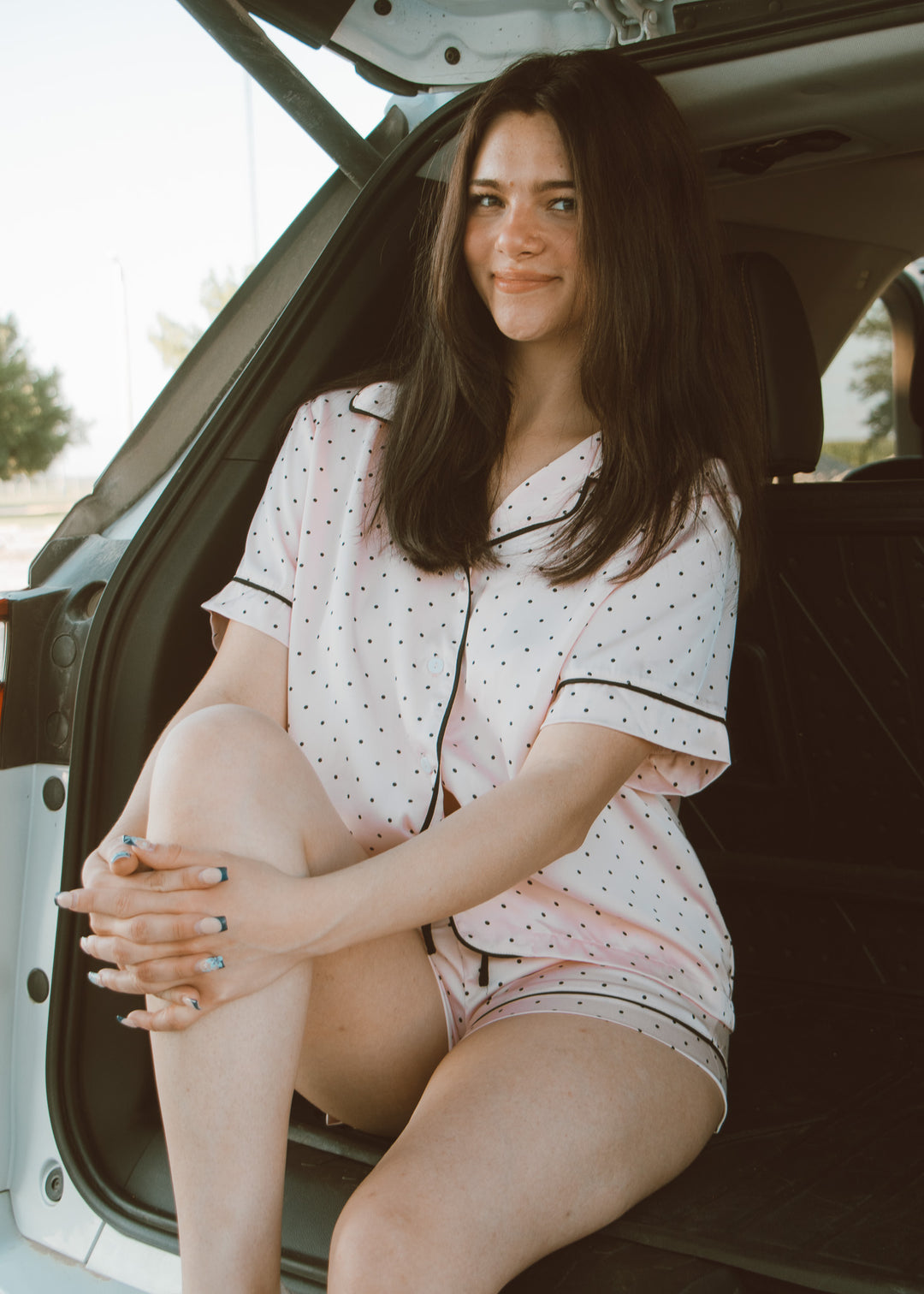 Woman in pajamas sitting in the back of a car