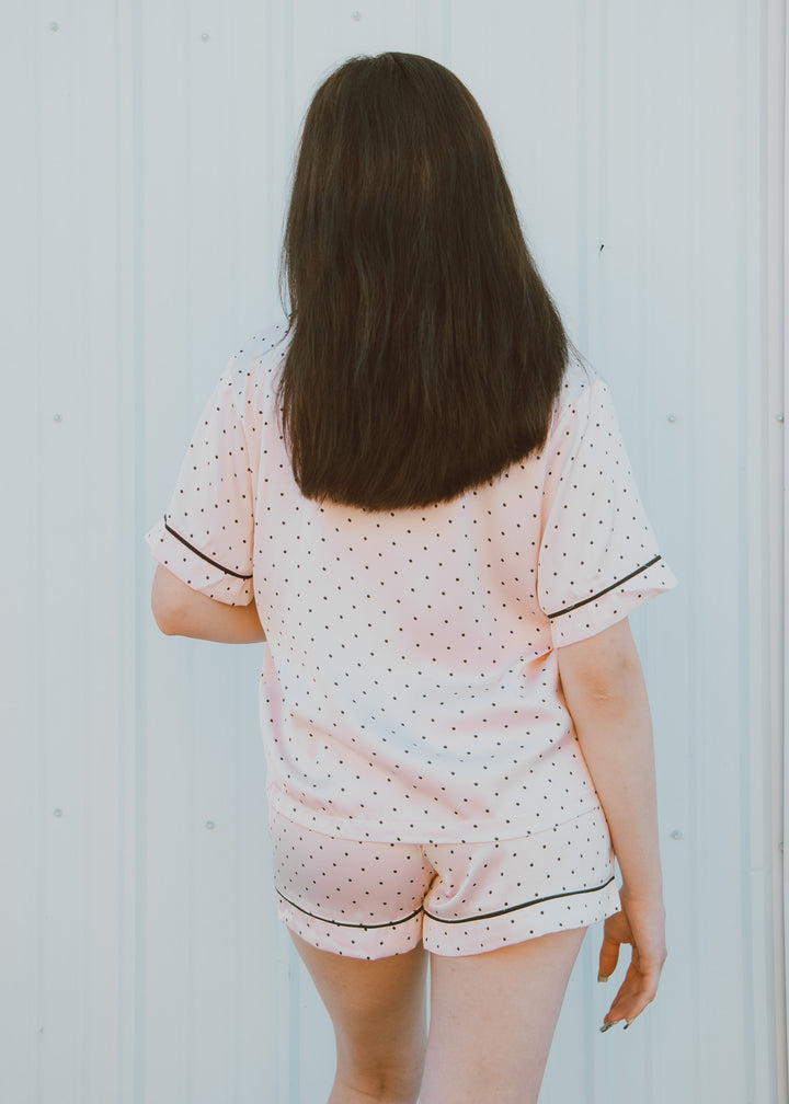 Person wearing a polka dot pajama set against a light background