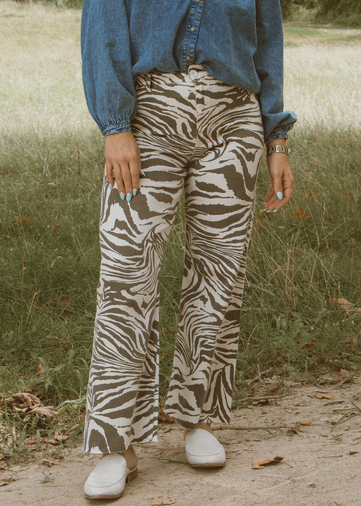 Person wearing zebra print pants and a blue shirt in a natural setting