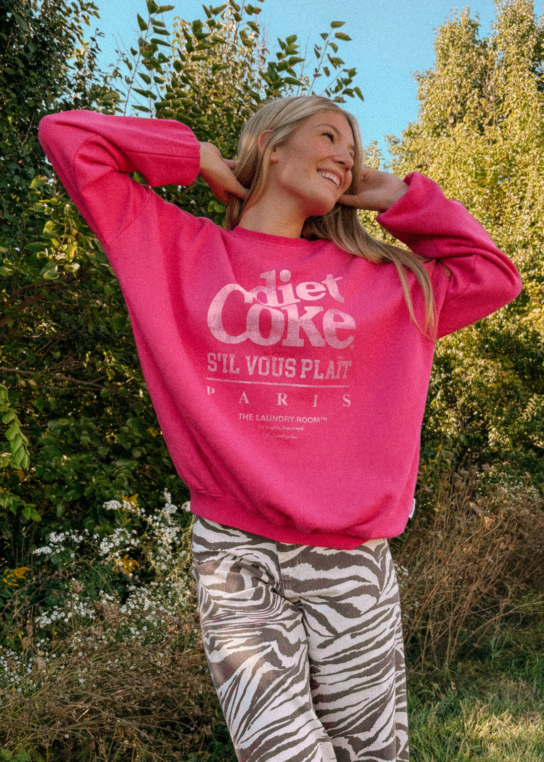 Person wearing a pink sweatshirt with text outdoors