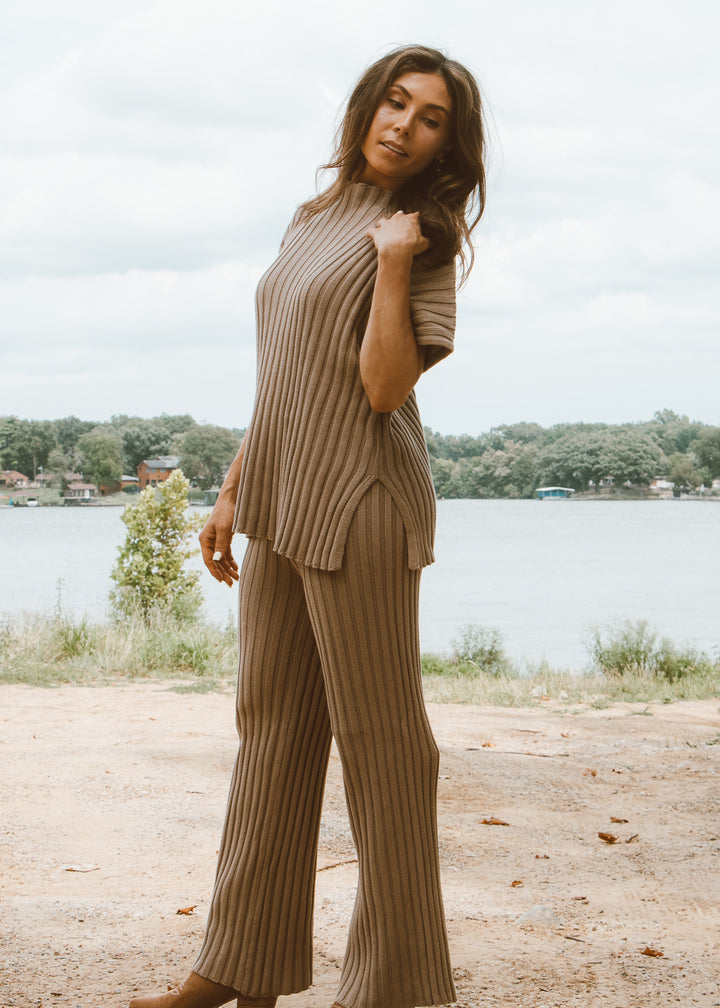 Woman wearing a ribbed knit outfit by a lake