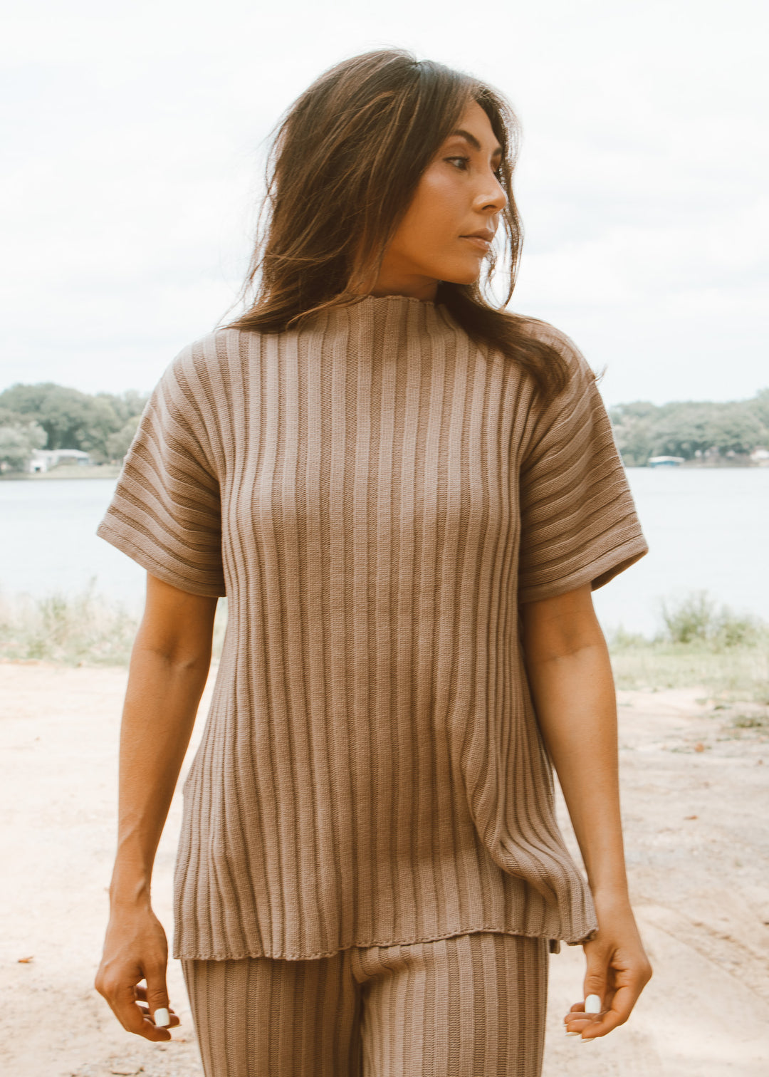 Woman wearing a ribbed brown top and pants outdoors.