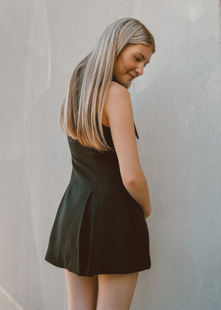 Woman wearing a black dress against a plain background