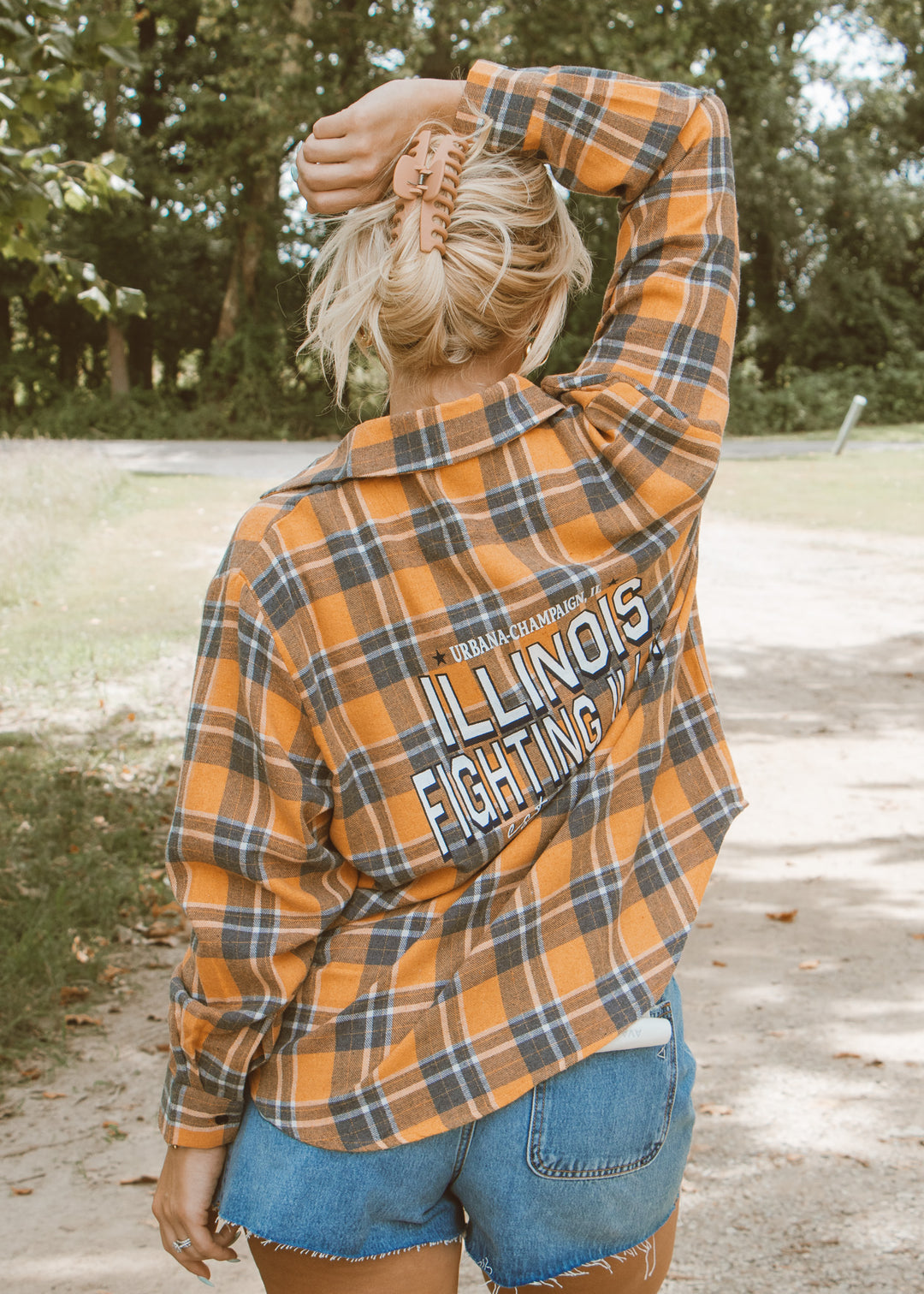 Person wearing a plaid shirt with 'Illinois Fighting' text outdoors