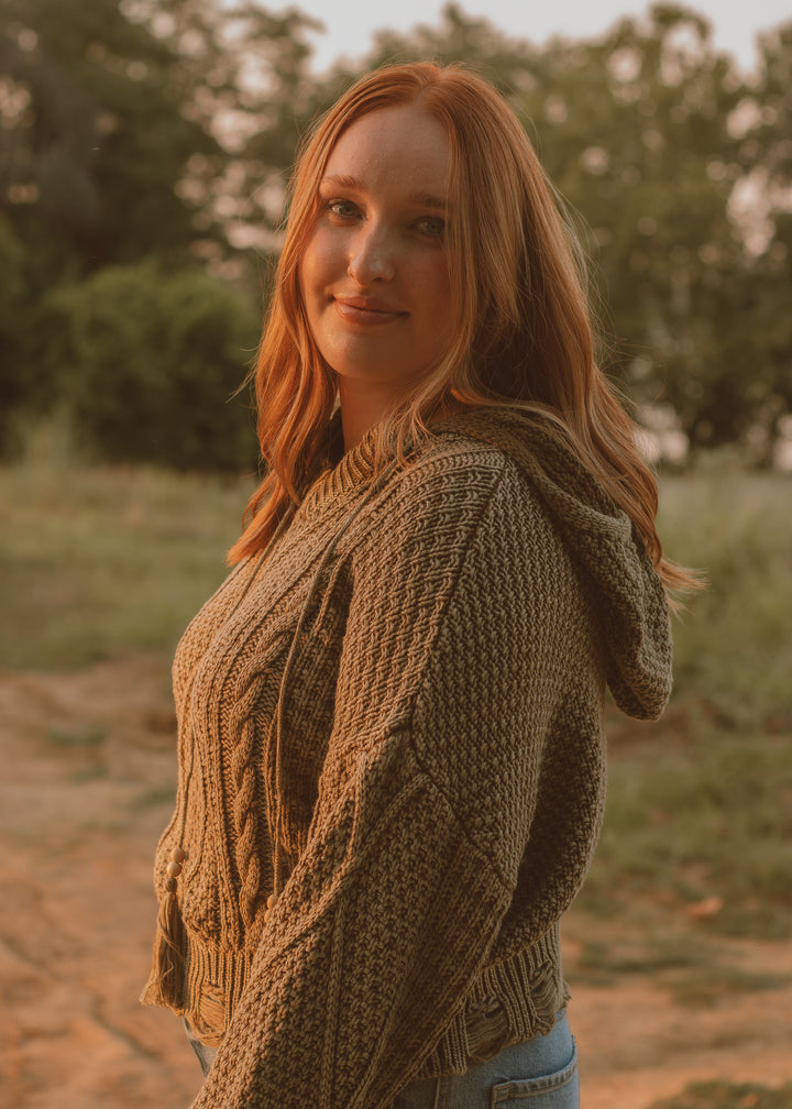 Woman wearing a green knitted sweater in a natural setting