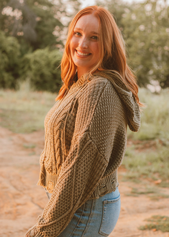 Woman wearing a green knitted sweater in a natural setting