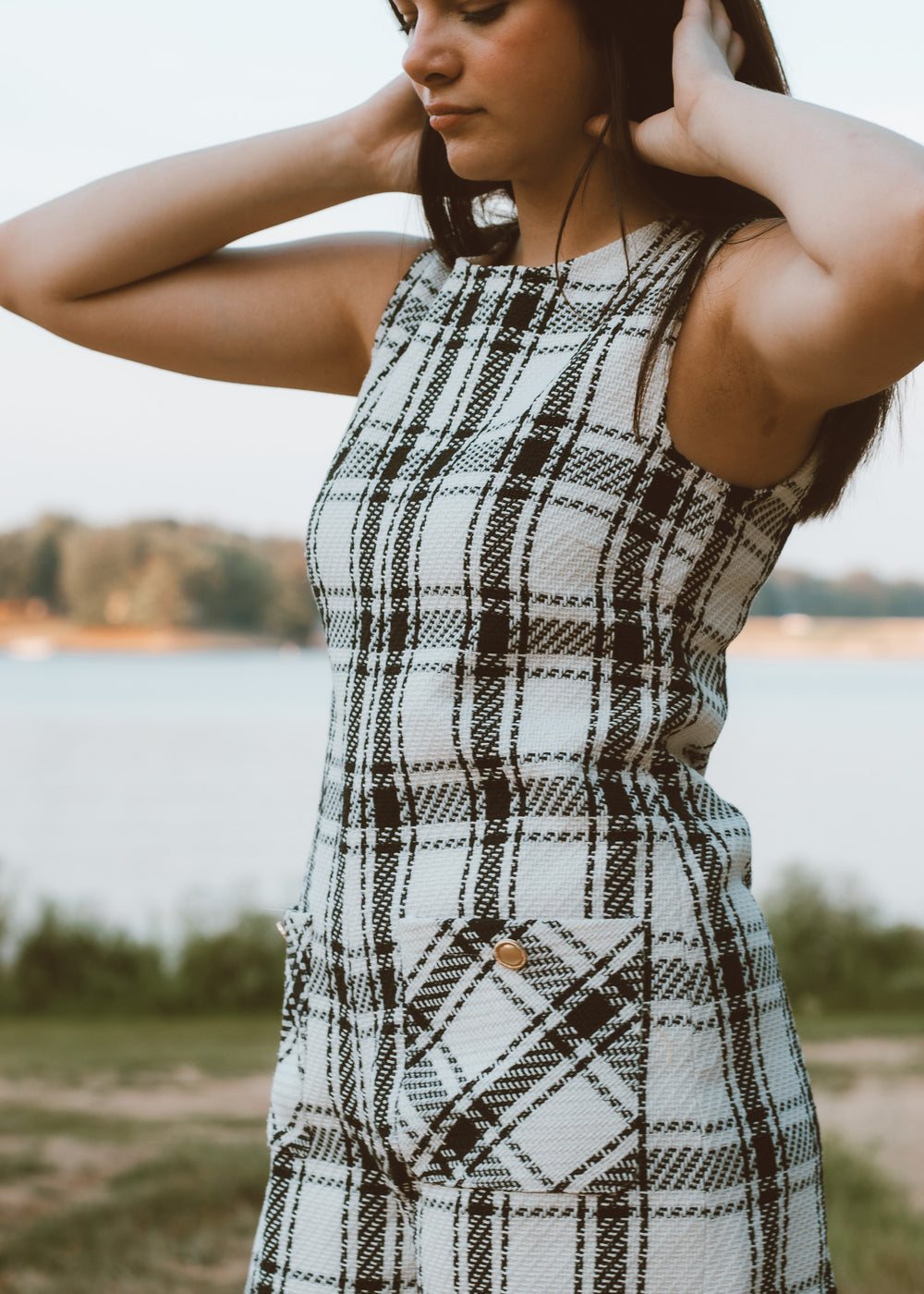 Woman wearing a plaid dress by a lake