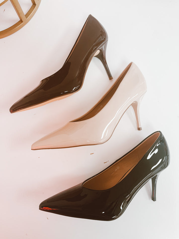 Three high-heeled shoes in brown, beige, and black on a white background